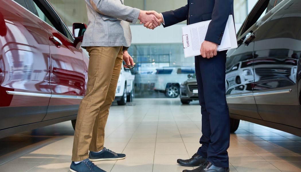people-shaking-hands-in-car-showroom.jpg